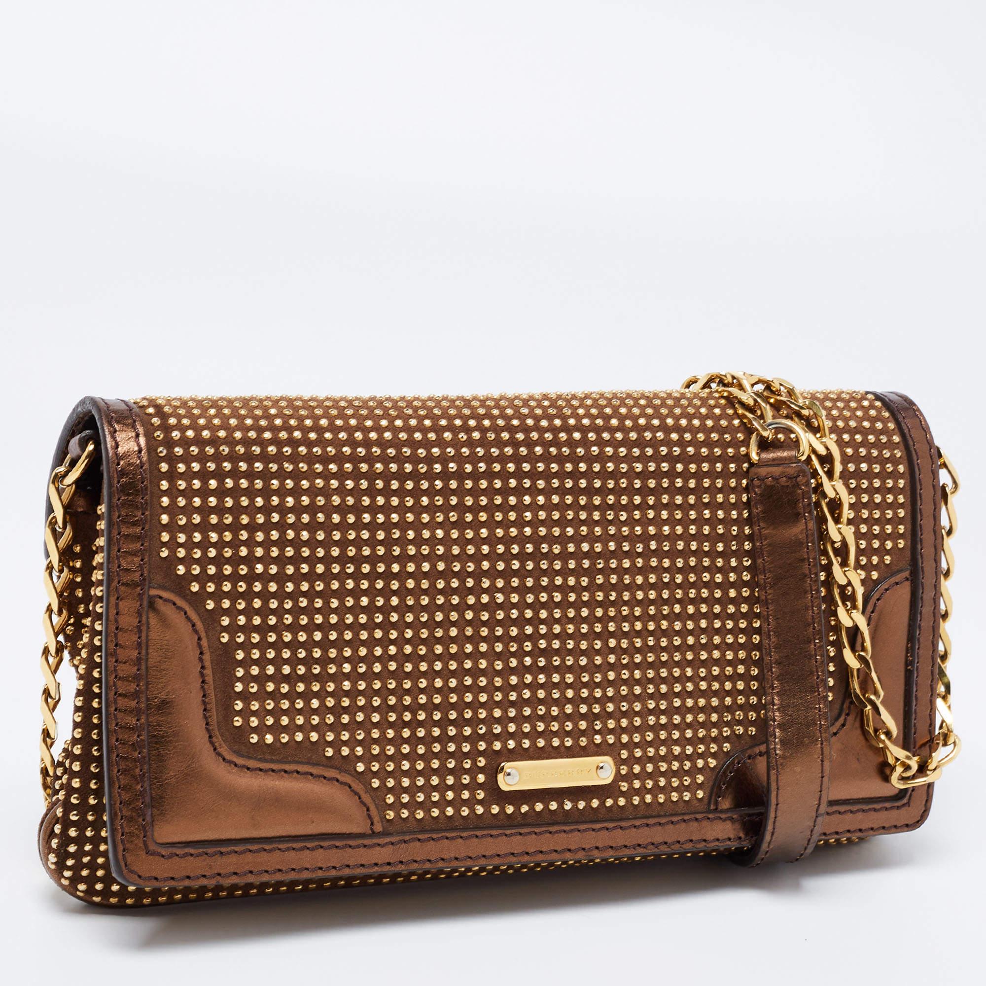 Gorgeous and functional, this shoulder bag from Burberry is the perfect companion for days when you want to look chic! It is designed using brown and metallic-bronze studded patent leather and suede. It flaunts a sturdy strap, gold-tone hardware,