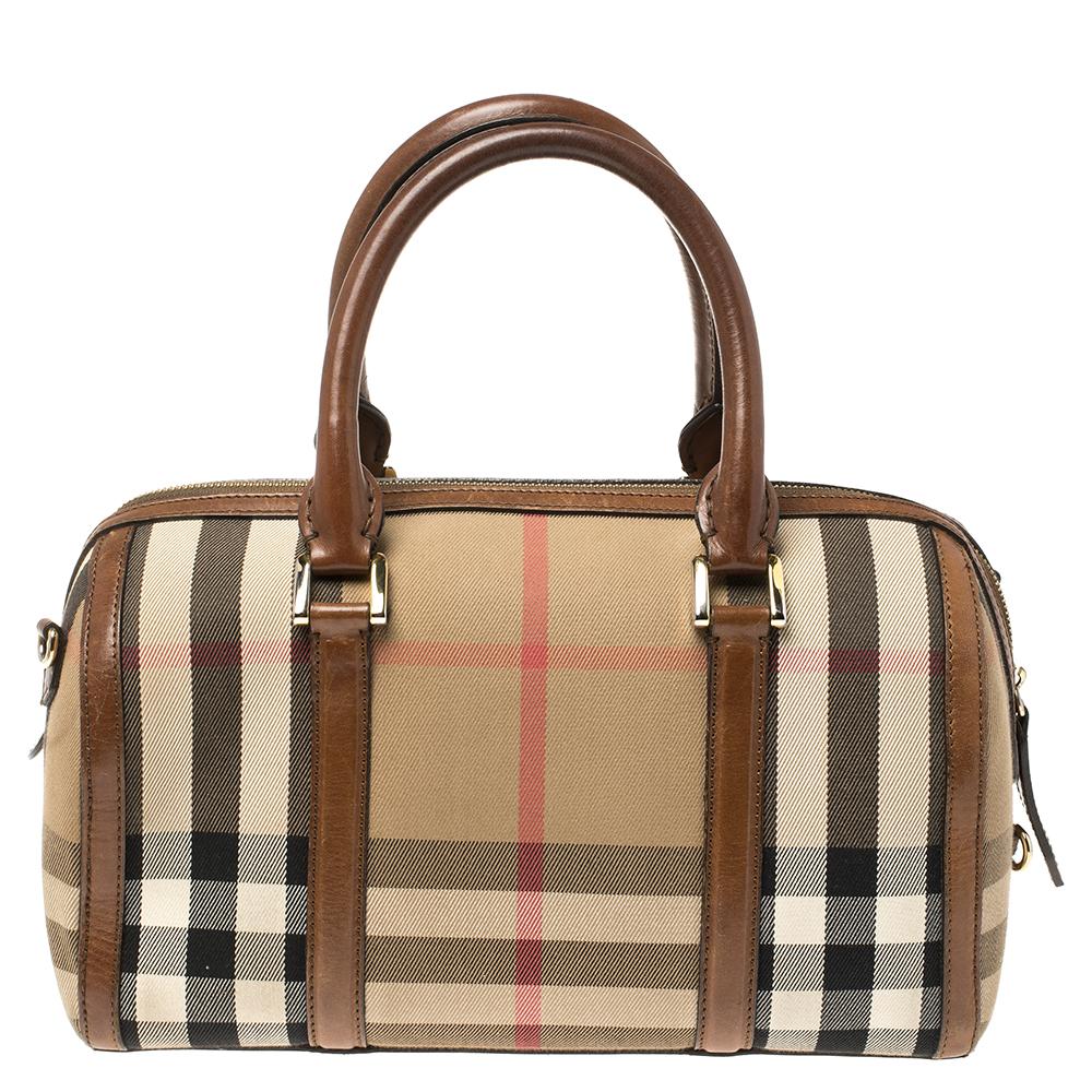 A stunning blend of autumn colors in leather & Nova check coated canvas make this Burberry Alchester Bowling Bag an instant classic. Ideal for your everyday essentials, this barrel-shaped bag features dual handles, a removable shoulder strap, and