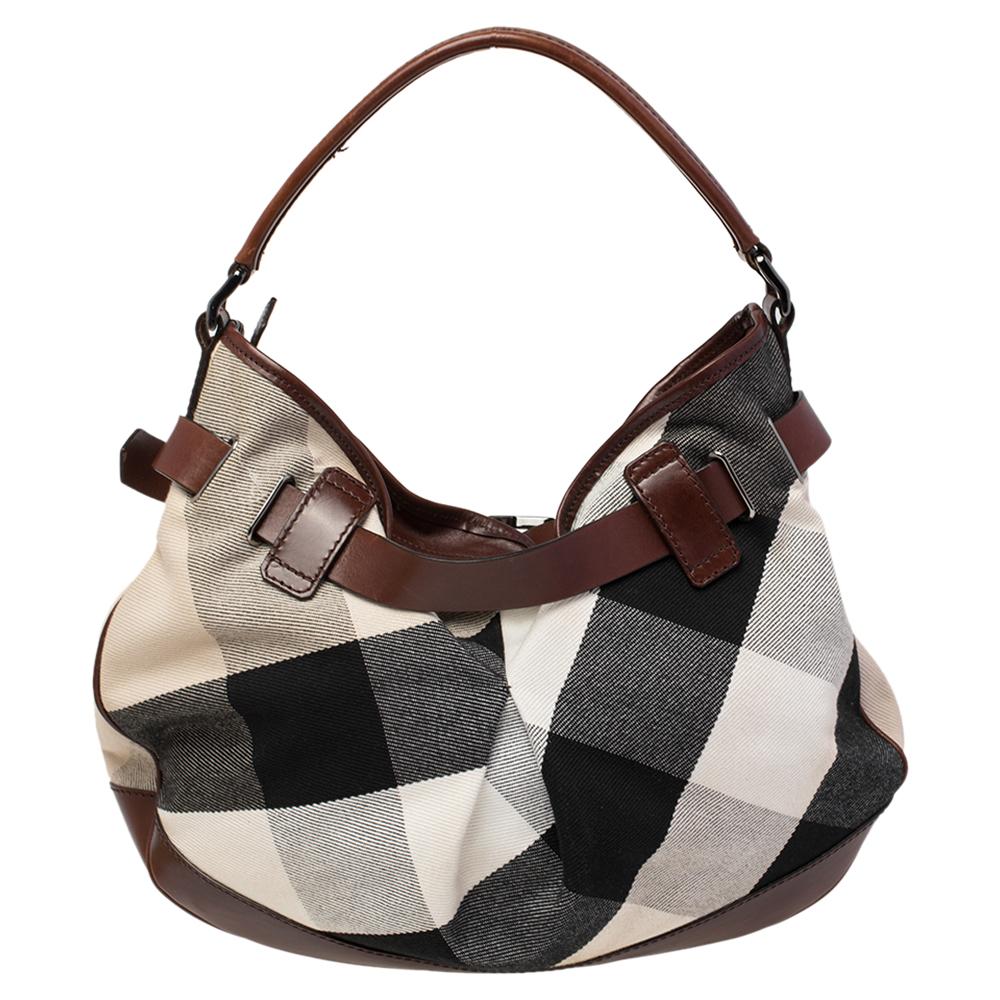 This bag from the British label Burberry is a classic creation. Highlighted by the elegant Mega Check pattern on the canvas exterior, this bag is equipped with leather trims, black-tone hardware, a spacious canvas interior, and a single handle.