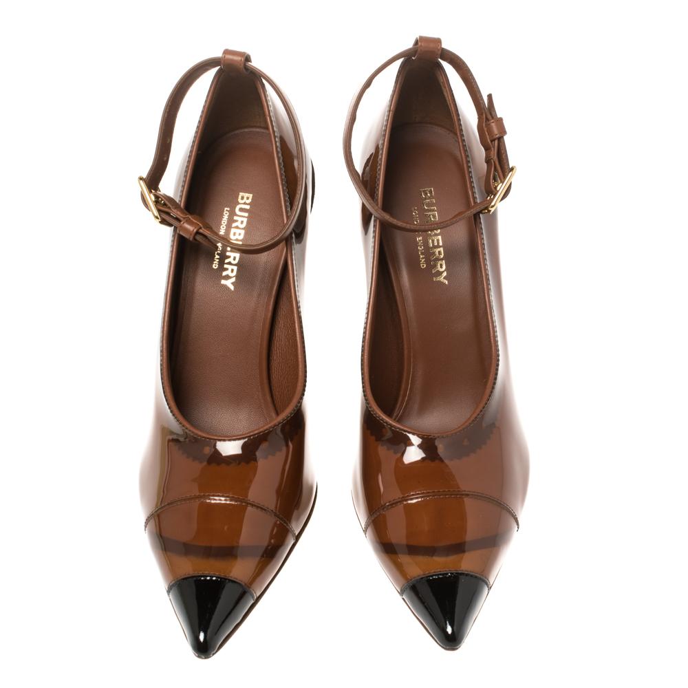 Created with contemporary design aesthetics, these stunning Burberry pumps are sure to be a worthy investment! They are finely crafted from brown PVC and patent leather and feature a pointed-toe silhouette. They flaunt ankle straps with a gold-tone