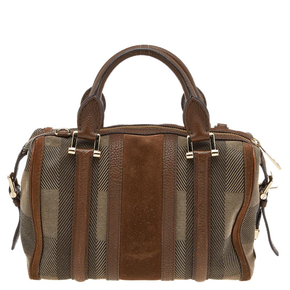 Spacious and captivating, this Nevinson Bowling bag comes from the House of Burberry. It has been crafted from brown suede, canvas, and leather, with a gold-toned logo plaque perched on the front. It is completed with dual handles and a roomy