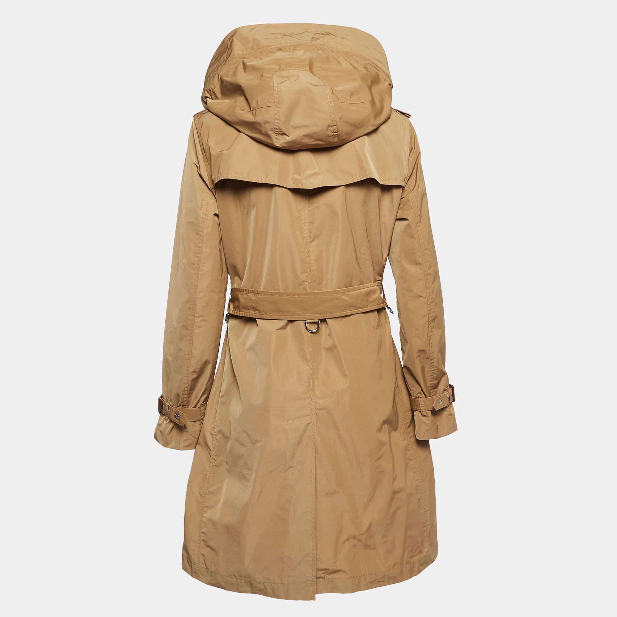 Embrace timeless style with the Burberry trench coat. Crafted with meticulous attention to detail, this coat exudes sophistication effortlessly. Its detachable hood adds versatility, while the rich brown hue complements any ensemble. Perfect for