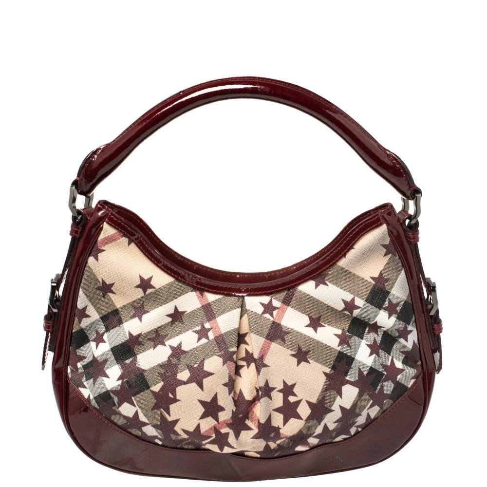 Classic with an edgy twist, this Burberry Hernville hobo is a handbag you’ll love wearing every day. The exterior is crafted from star check patterned PVC, which is detailed with patent leather trim, and a short handle. Its large interior is lined