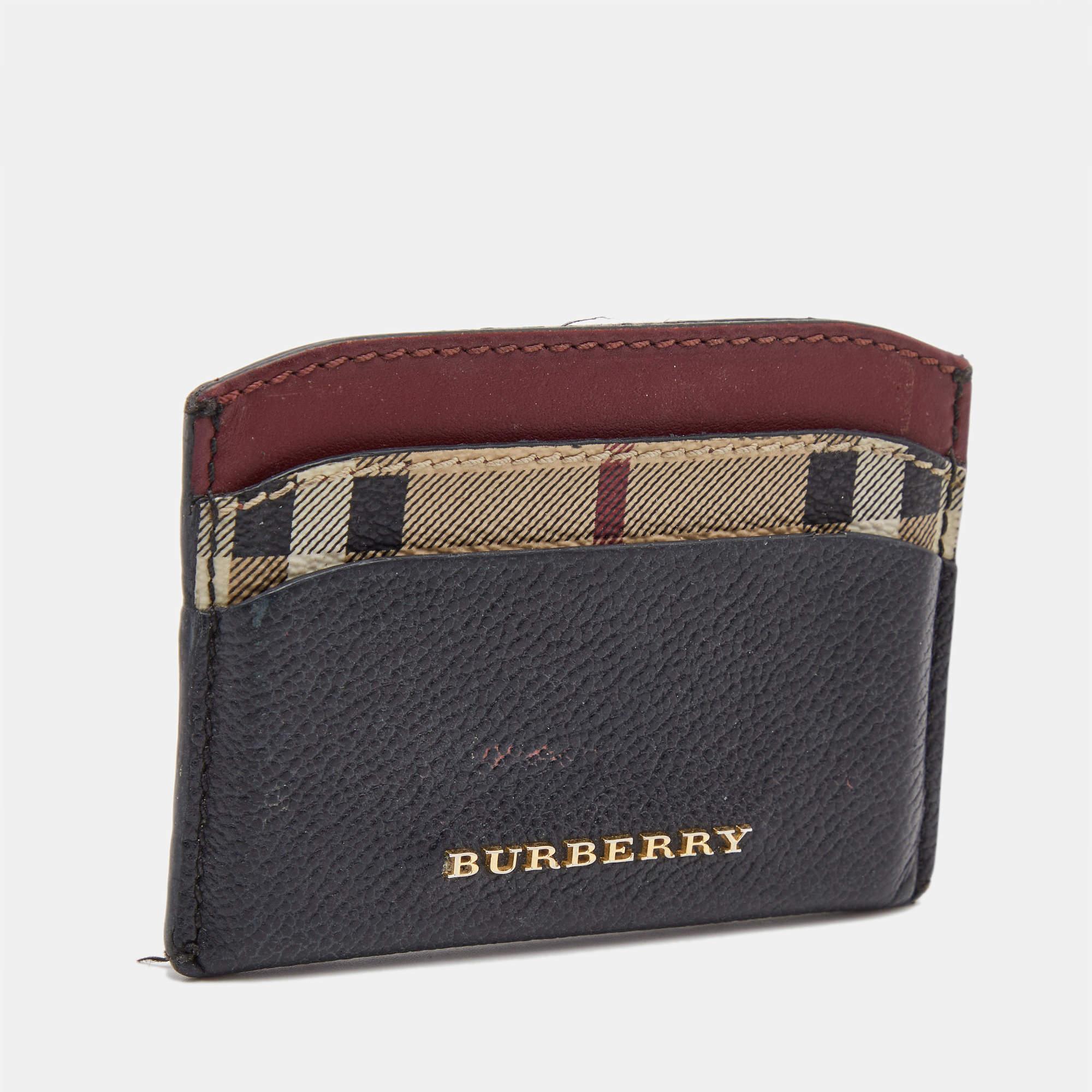 Designed by Burberry, this card case made from leather and check canvas is the perfect accessory to keep your cards in proper order, as it features multiple slots. It has the brand name on the front.

