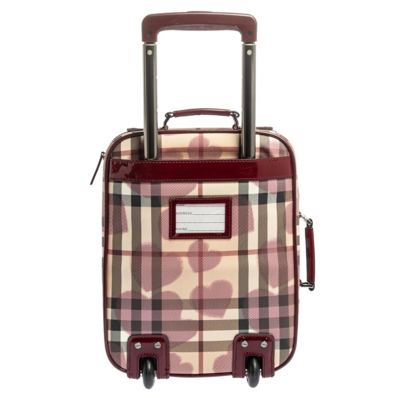Let your travels be full of ease with this Burberry bag. Made from Heart Check Coated Canvas and patent leather, this two-wheeled trolley bag comes with a top handle, a telescopic handle, and an exterior pocket secured by a zipper. It has a spacious