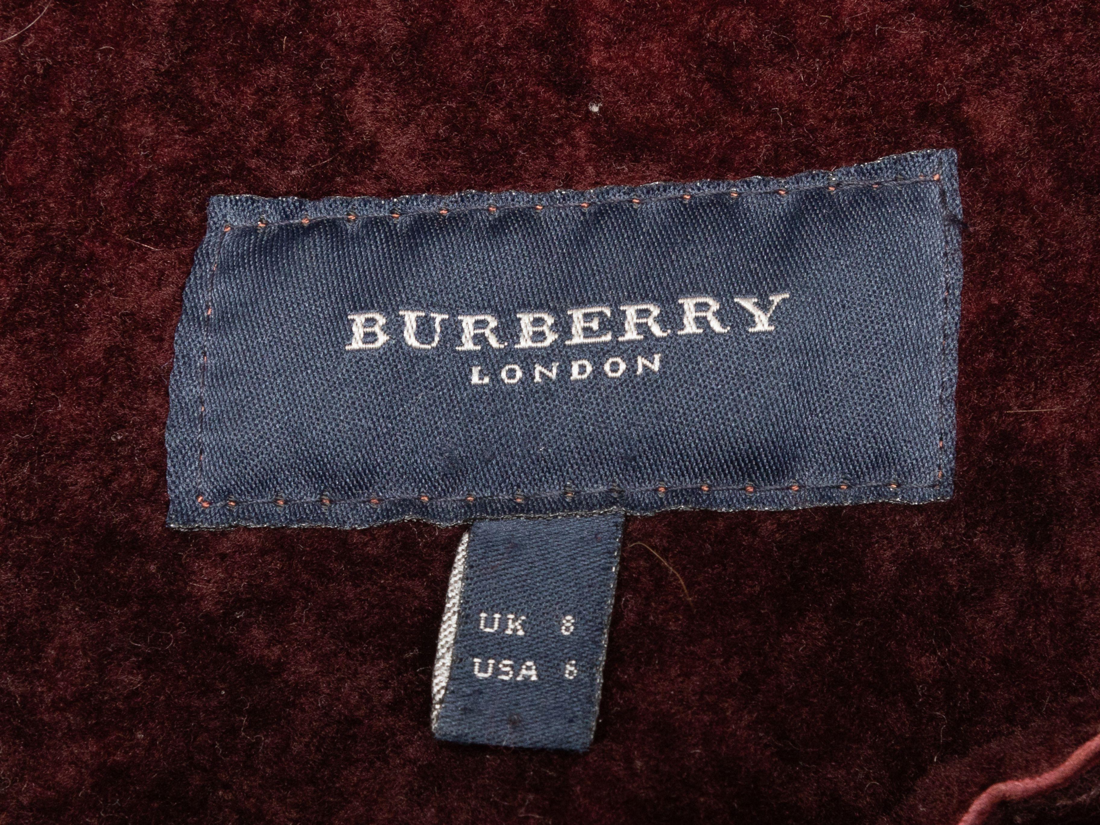 Product Details: Burgundy long shearling coat by Burberry. Pointed collar. Dual hip pockets. Button closures at center front. 37