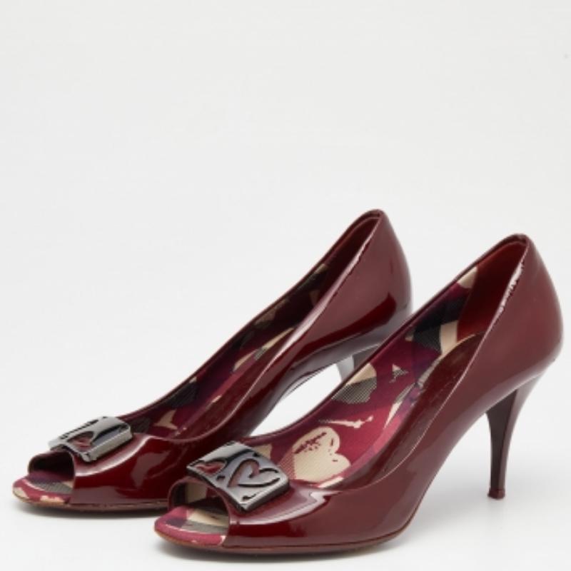 Este par de zapatos de salón de Burberry muestra una mezcla perfecta de encanto y elegancia. Cosidos en charol, los zapatos burdeos tienen puntera abierta y detalles en bronce de cañón en la pala, y tacón de 8 cm.