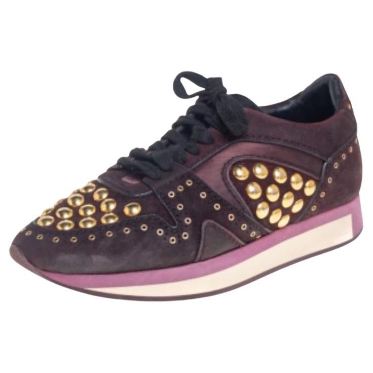 Let this pair of low-top Burberry sneakers elevate your style this season. Crafted from burgundy suede and satin, these sneakers feature round toes, lace-ups on the vamps, and gold-tone stud embellishments. They are made comfortable with