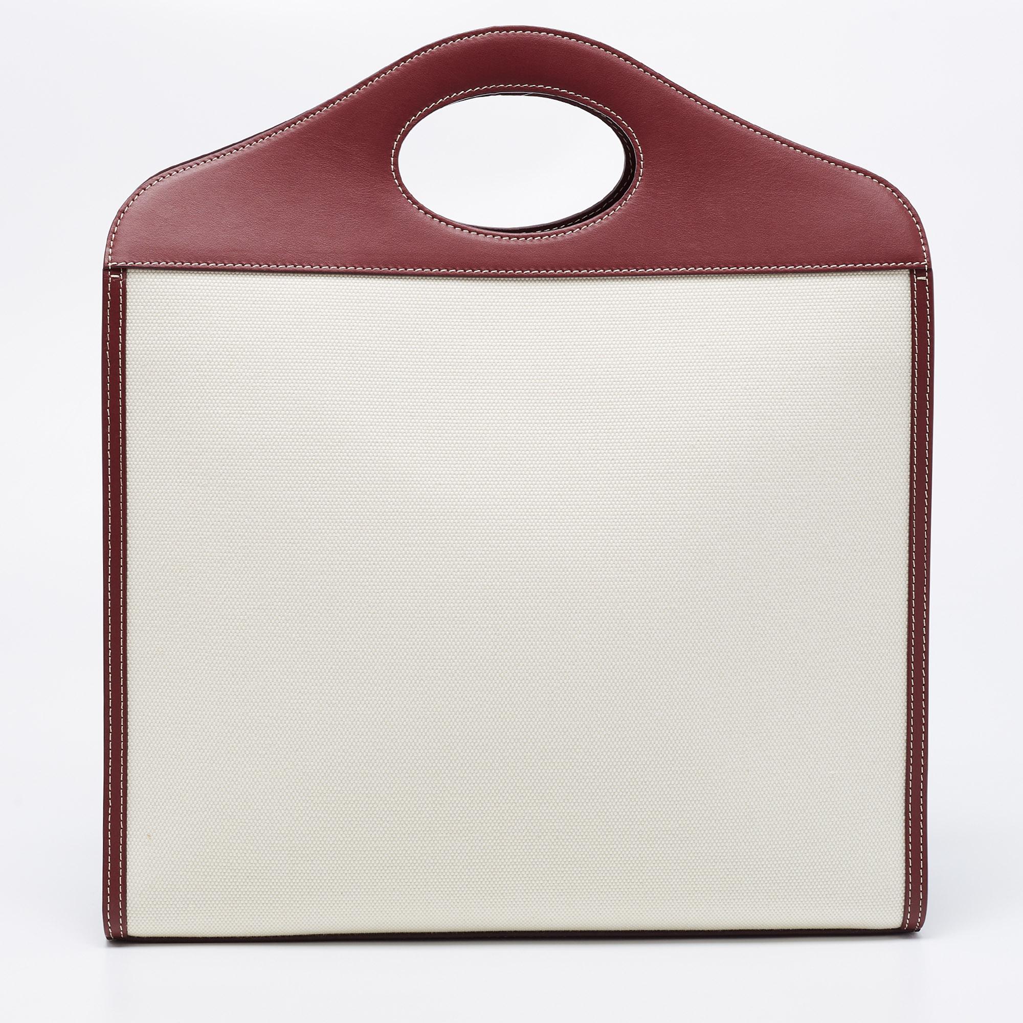 With a chic, structured design, this Burberry bag is sure to earn you admiring glances. It is made from canvas and leather and has a burgundy-white body with gold-tone details. It is finished with stylish dual handles, a strap, and a roomy interior