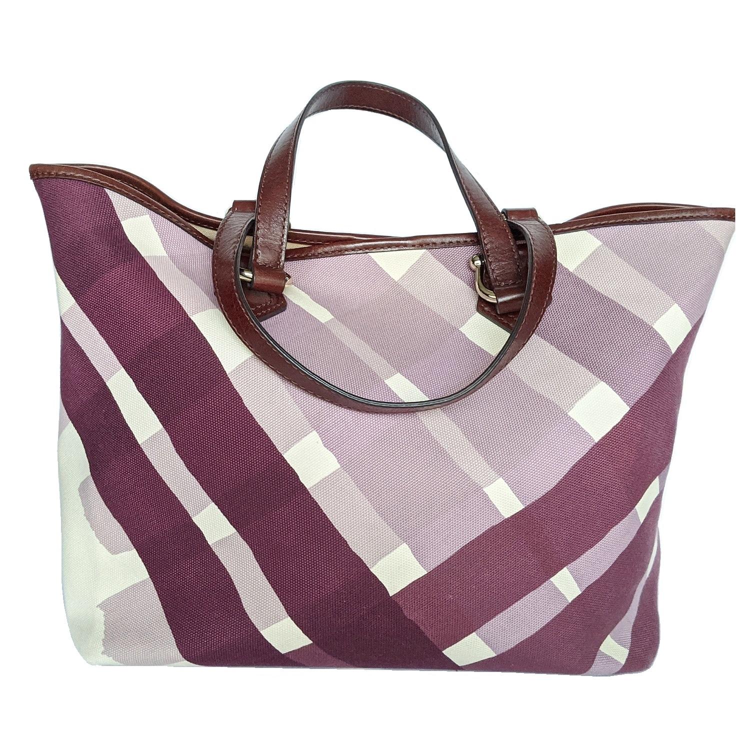 This is a lovely tote that is beautifully crafted of a checked canvas in graduating tones of purple. The bag features dark purple tall leather strap top handles with polished silver-tone hardware. Magnetic closure open to a spacious fabric interior