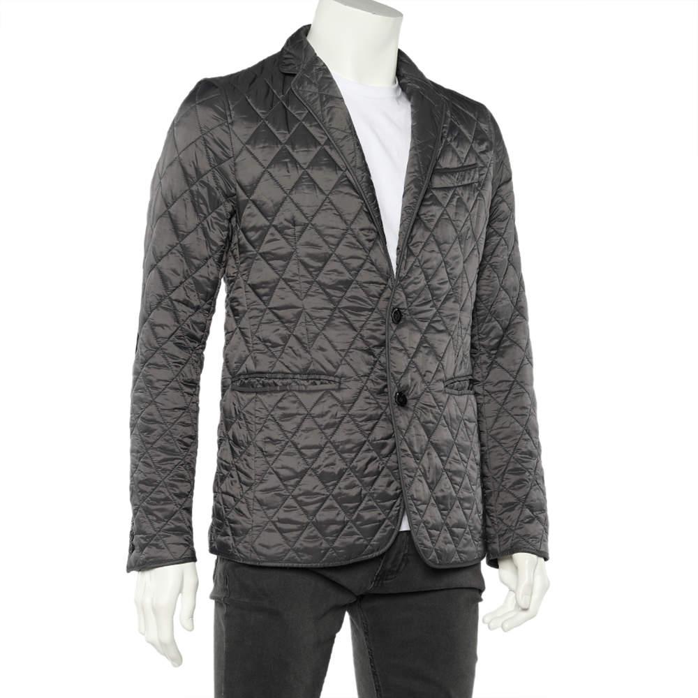 La maison Burberry vous propose cette superbe veste pour rehausser votre style. Il est conçu en tissu synthétique matelassé gris anthracite, avec des détails contrastés sur les coudes. Il est doté de fermetures boutonnées, de poignets boutonnés et
