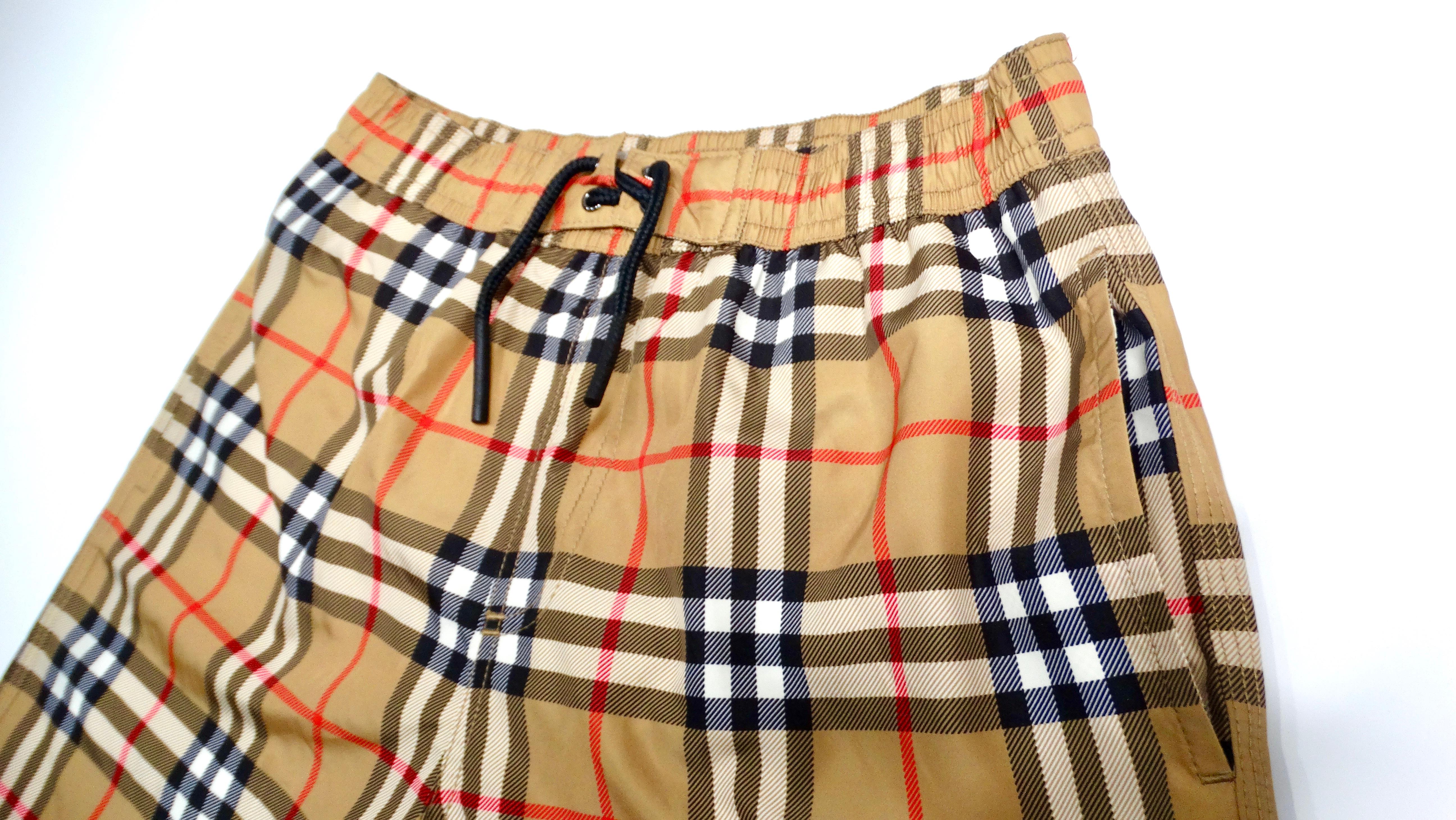 Elevate your little boy’s summer wardrobe with the stylish Burberry Children Antique Yellow Plaid Boys' Swim Trunks. These eye-catching swim trunks feature a classic plaid pattern in a warm antique yellow hue, embodying Burberry’s timeless elegance
