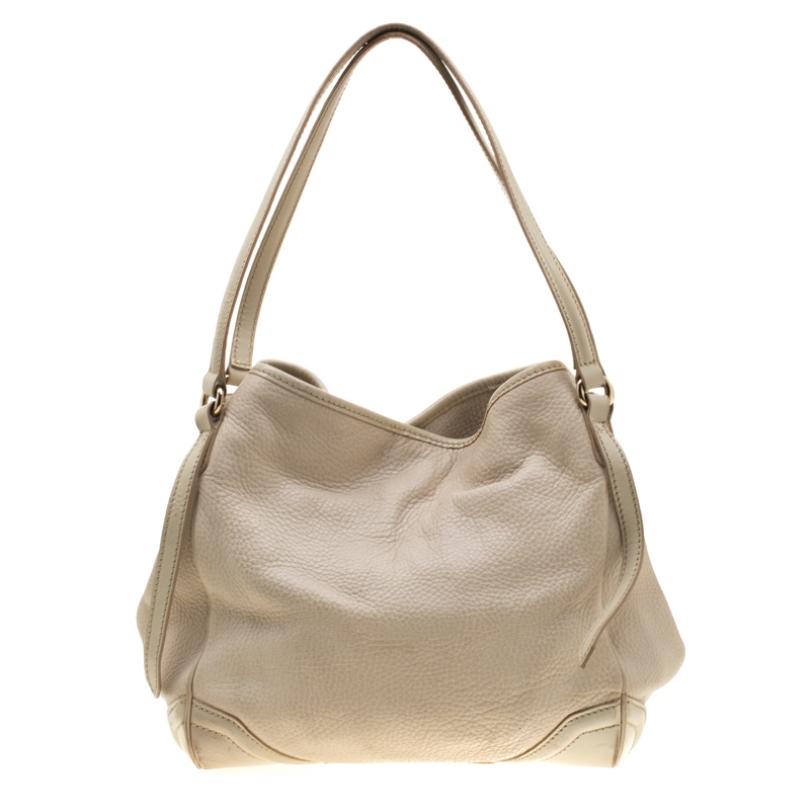 Get your hands on this fine leather piece to complement your work-week look. With a fabric-lined interior and two handles, it is a beautiful brew of standard and sophistication. It is time for you to own a Burberry bag. Covered in a cream hue, this
