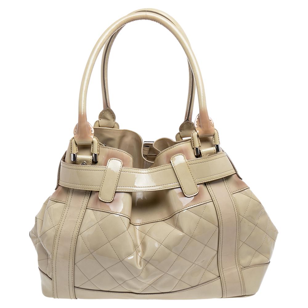 Burberry's finest range of totes includes this beauty here. It is crafted using quilted patent leather, detailed with a buckle strap, and held by two top handles. The designer tote is lined with satin and complemented with silver-tone