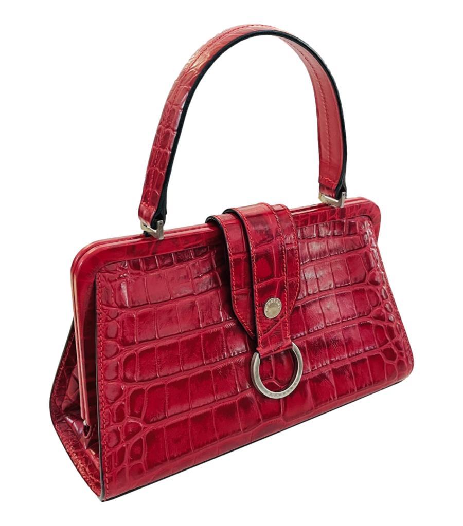 Burberry Croc Embossed Leather Handbag
Red bag crafted in crocodile embossed leather and detailed with silver hardware with 'Burberry' engravement.
Featuring single top handle and snap closure leading to signature Burberry check lining with zipped