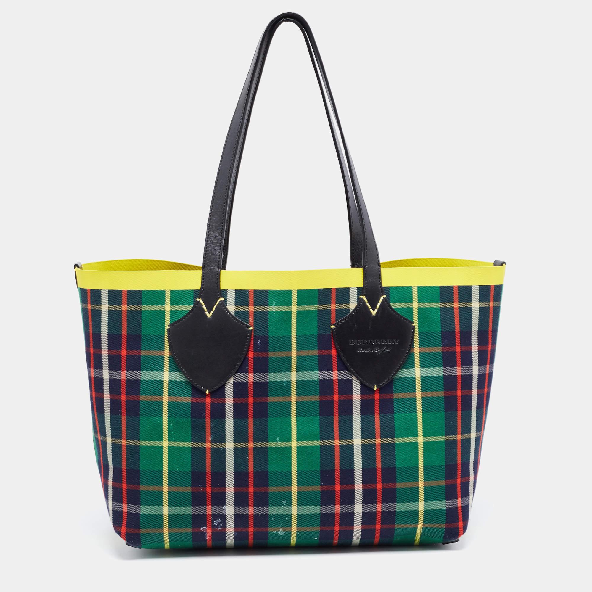 This Reversible tote by Burberry has a structure that simply spells ease. Crafted from check canvas, the bag is elegantly held by two leather handles. The tote comes with a reversible interior with enough space to store your necessities.

