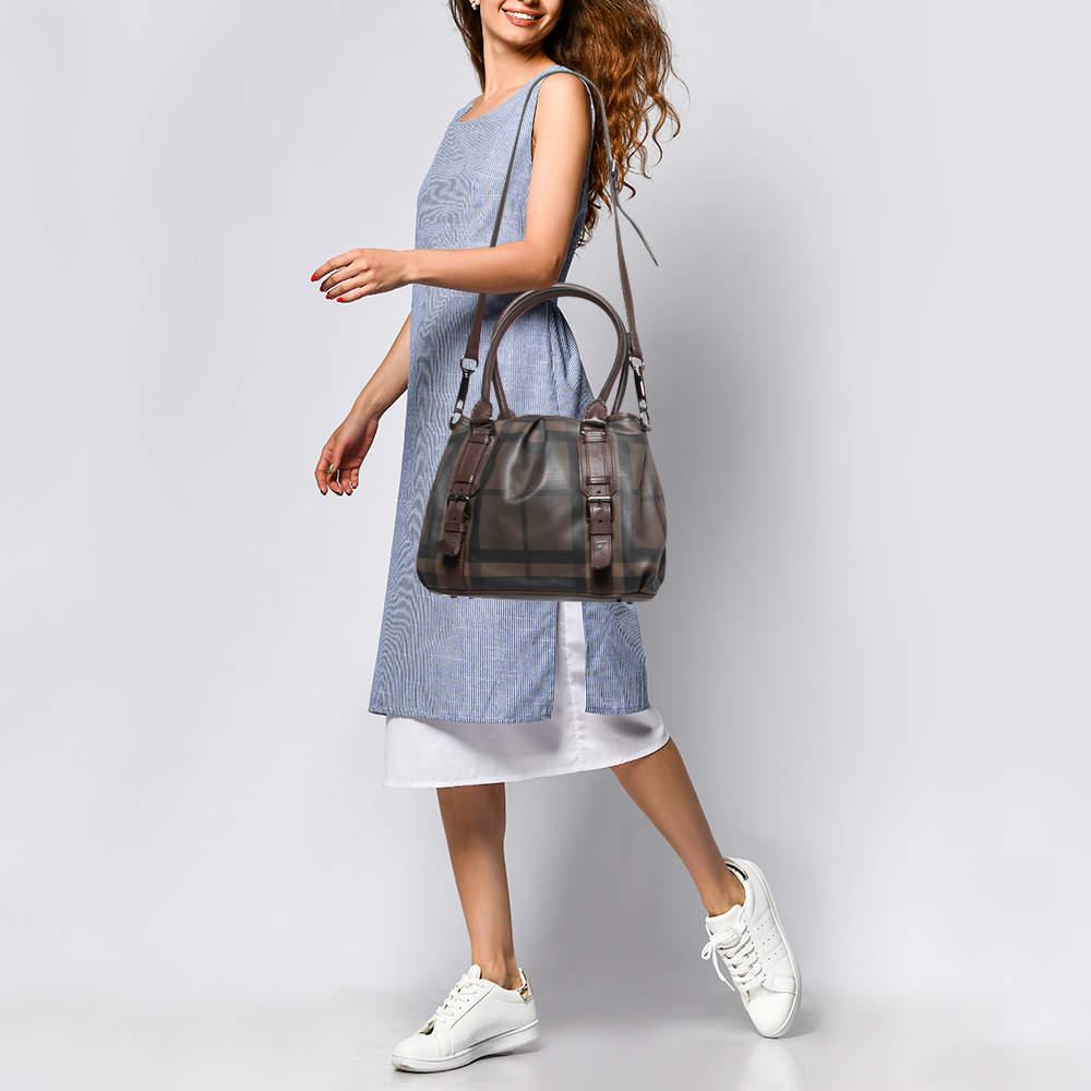 This Northfield tote from Burberry is crafted from signature Smoke check coated canvas and leather. It is equipped with two rolled handles, a detachable shoulder strap, and a well-sized canvas interior to house your belongings. The dark brown shade