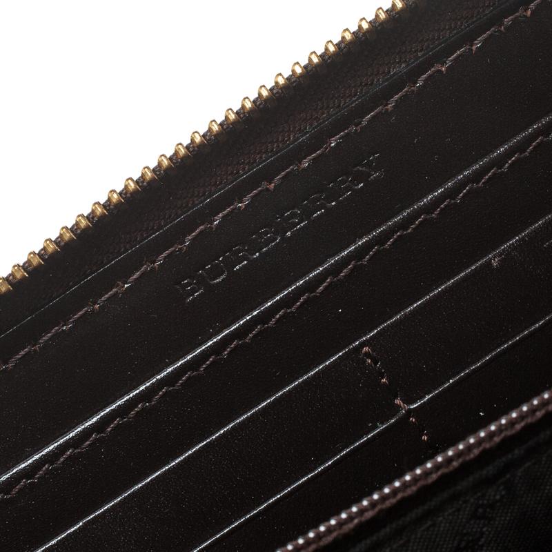 This dark brown wallet from Burberry definitely needs to be on your wishlist! It is crafted from leather and features a striped stitched pattern. It flaunts a zip around closure that opens to reveal a leather and nylon interior with card slots and