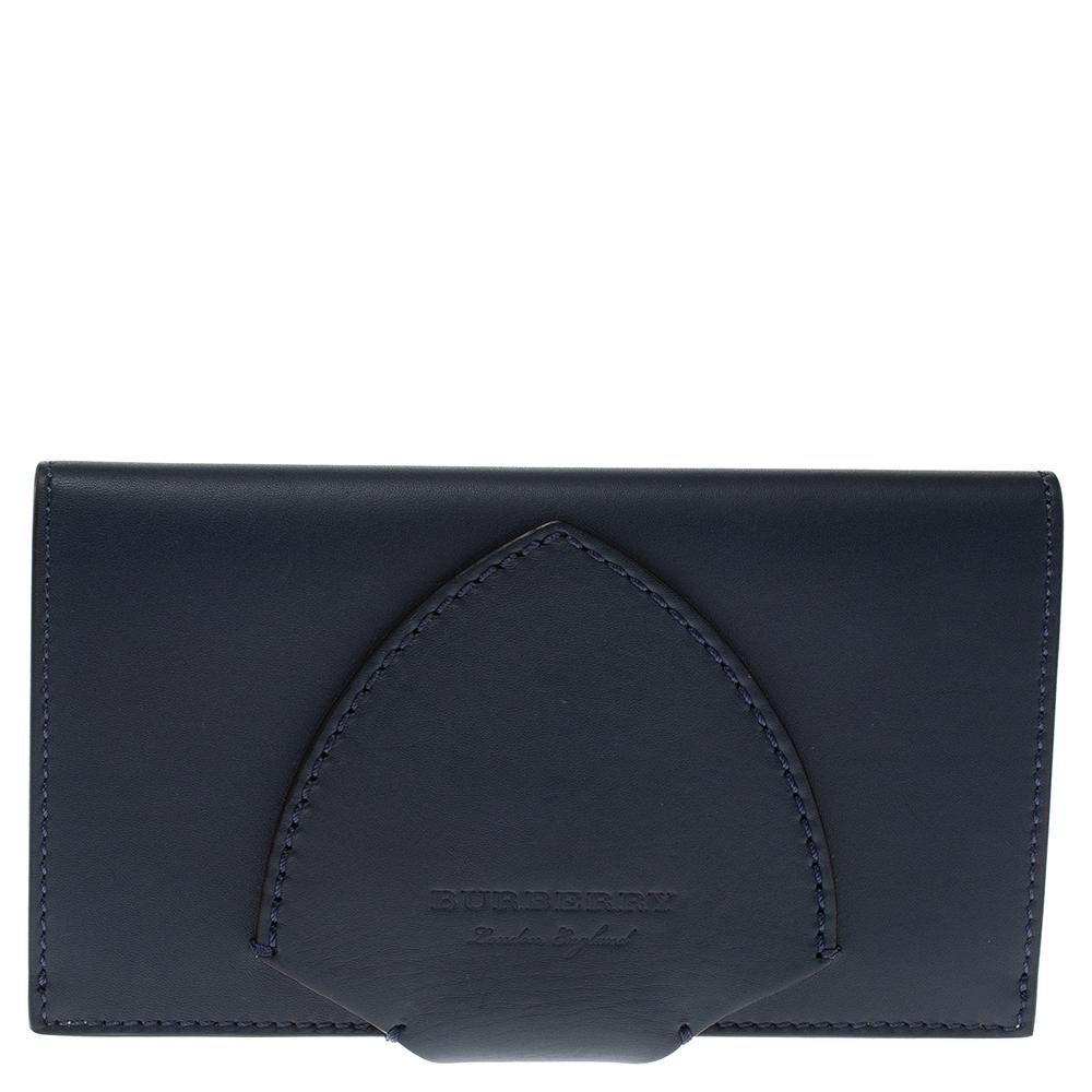 This Harlow wallet from Burberry is a wonderful creation! This dark indigo wallet is crafted from leather and features a smooth finish all over the exterior along with the brand logo on the strap. The wallet opens to a leather interior that houses