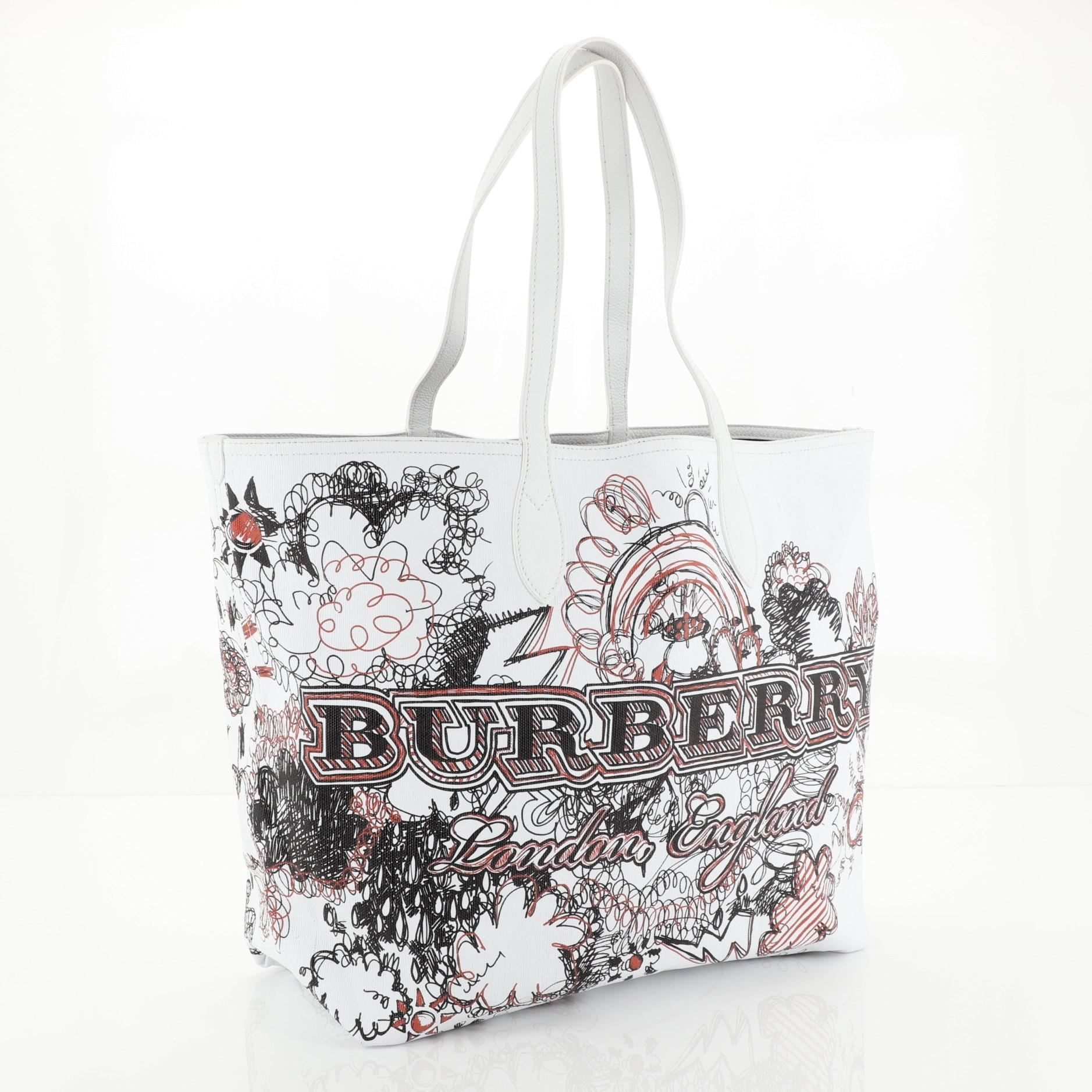 This Burberry Doodle Reversible Tote Printed Canvas Large, crafted from white printed coated canvas, features dual top handles. It opens to a reversible brown House Check canvas interior. 

Estimated Retail Price: $795
Condition: Great. Minor wear