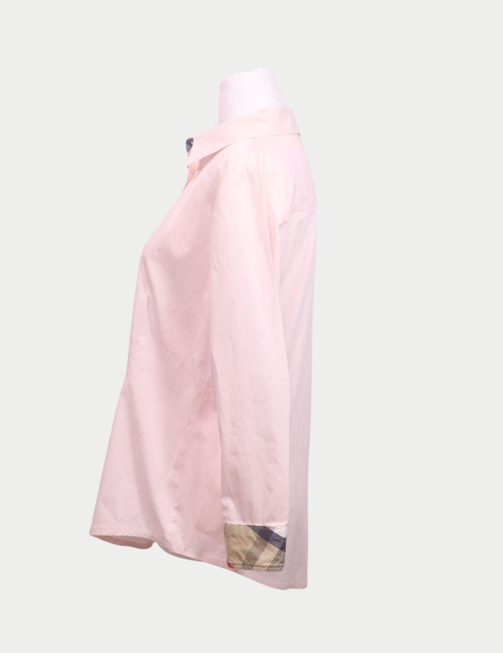 Camisa abotonable Burberry de algodón rosa palo con puños de cuadros de la firma

Esta camisa abotonada Burberry aporta una elegancia atemporal con un toque suave y femenino. Confeccionado en algodón fresco en un tono rosa pálido, presenta una