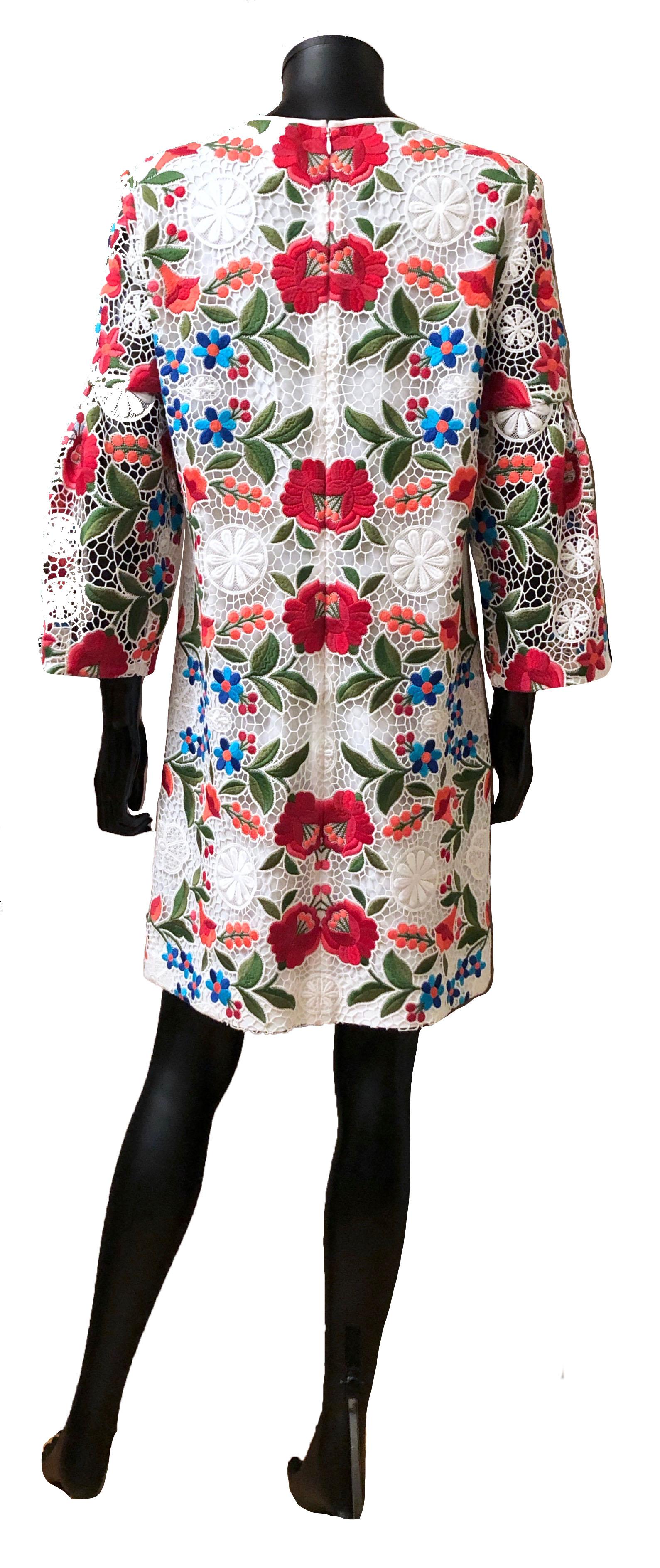 This exquisite multicolor floral embroidered white lace shift dress features a jewel neckline and three-quarter bell sleeves.
It has a hidden back zip.
   
Collection: 2018
Fabric: Outer - 85% cotton, 15% polyester ; Lining - 67% Acetate, 33%