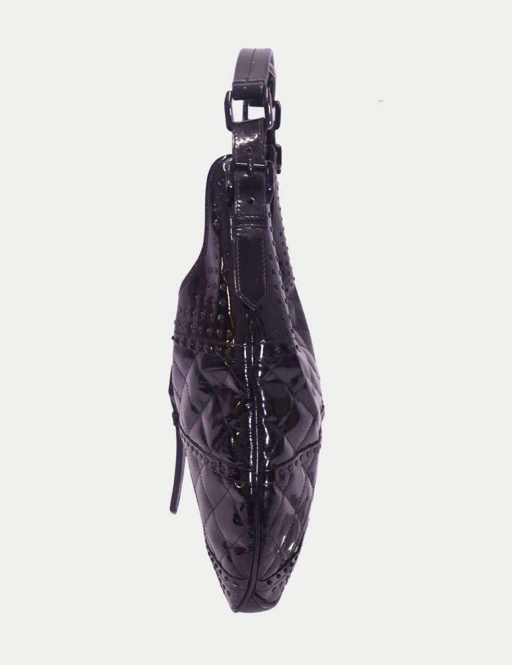 Burberry Black Patent Leather Quilted Hobo Bag

Polish your everyday wardrobe with this Burberry Black Patent Leather Hobo Bag, a bold yet versatile piece that blends elegance with edge. Featuring quilted patent leather panels, studded detailing,