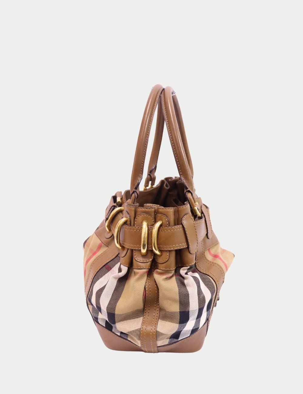 Entrez dans l'élégance britannique intemporelle avec ce sac à bandoulière Burberry, confectionné dans la toile à carreaux Nova emblématique de la maison et garni de cuir marron souple. Doté de ferrures dorées, de deux anses en cuir roulées et d'une