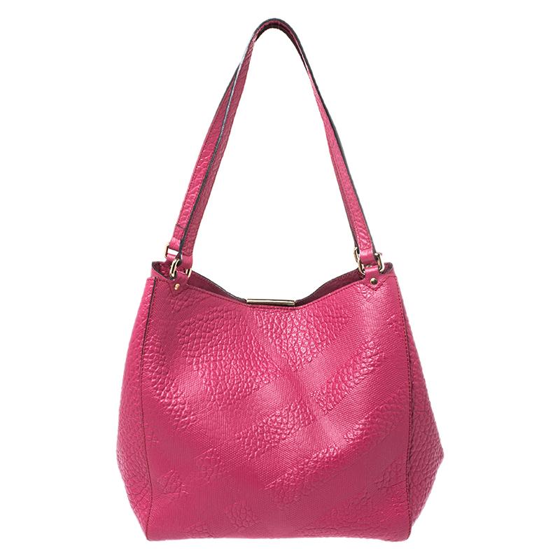 This practical Dewsbury tote by Burberry has a classic style. Crafted to perfection, it is made of leather and comes in a lovely shade of fuchsia. The bag is held by dual handles, features a nylon interior with enough space for your essentials. The