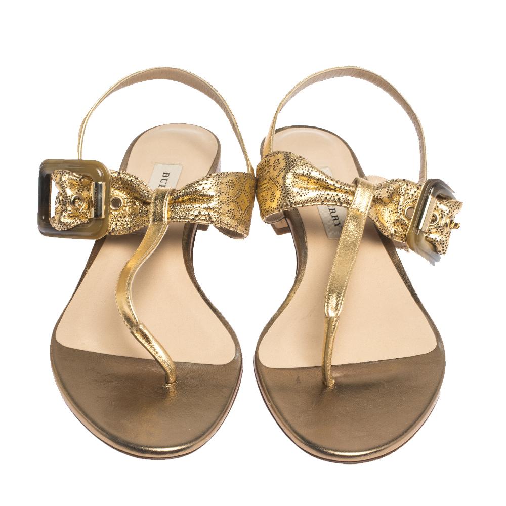This pair, crafted in metallic gold leather, is designed in a thong style with buckle details on the uppers. It is complete with short block heels and leather insoles. The simple design of these sandals will complement your versatile wardrobe