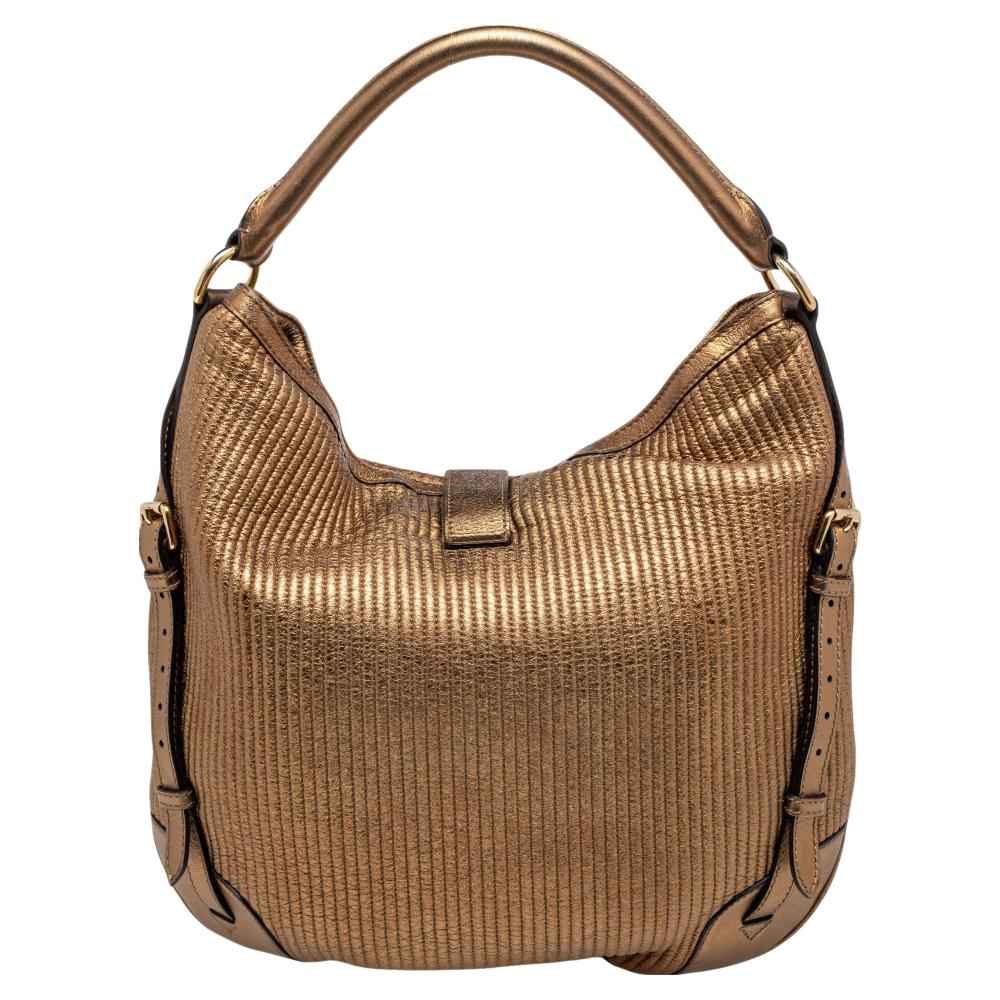 This Burberry hobo in quilted leather has an alluring design. Beautifully crafted, the bag comes with a highly durable exterior, a spacious canvas interior, a single handle, and gold-tone hardware. The creation is ideal for daily use.