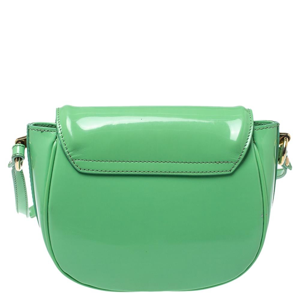 Burberry woos us once again with this green patent leather bag that is unique and functional. It features a smooth glossy leather exterior with a gold-tone logo plaque on the front flap. The creation has an adjustable shoulder strap and magnet snap