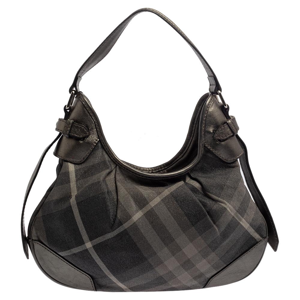 The British fashion house of Burberry has been renowned for its refined and fashion-forward luxury items. This Brooklyn hobo by Burberry is a head-turning everyday handbag. It is crafted from Beat Check canvas and is accented with leather trim. This
