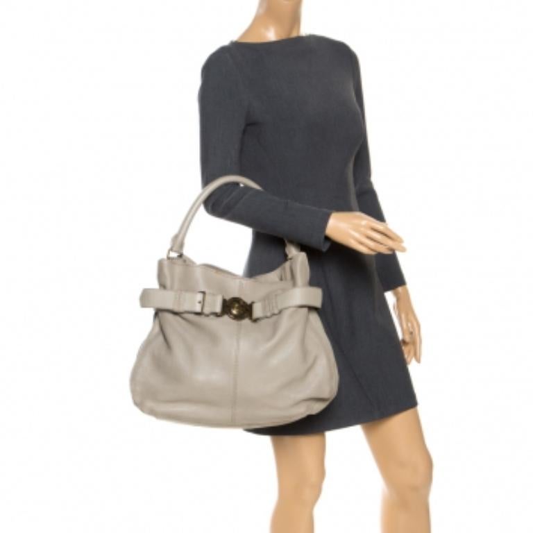 This soft, slouchy hobo bag from Burberry is in grey leather and finished with a wide band around the top. This is finished with a press-lock Burberry medallion in gold-tone. The interior is lined with the iconic Burberry check nylon. The single