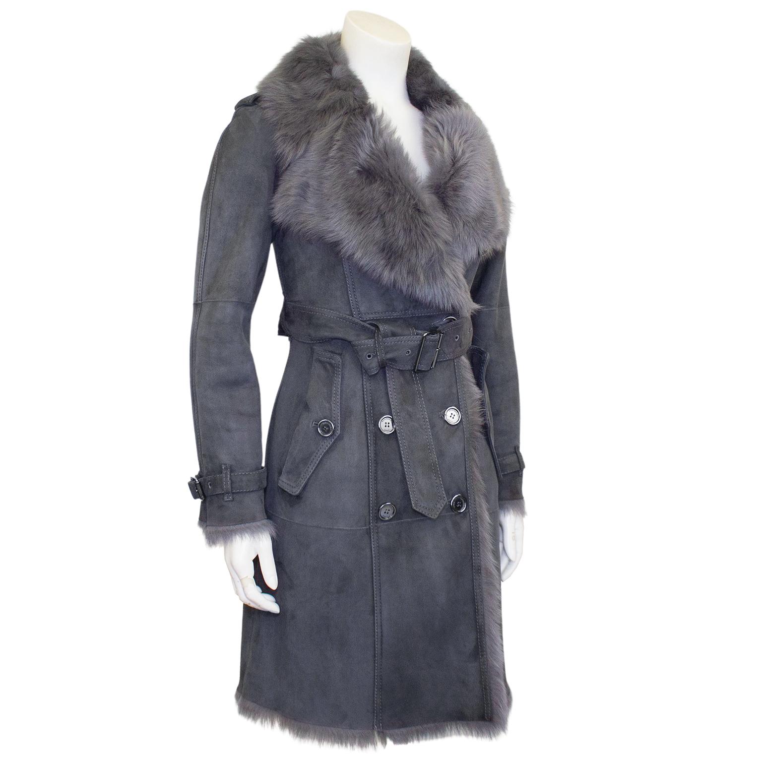 Fabulous Burberry trench coat. Grey suede with grey shearling interior. Double breasted with a large shearling collar. Round silver metal buttons with brand engravings. Can be worn with or without the matching grey suede belt at waist. Marked UK