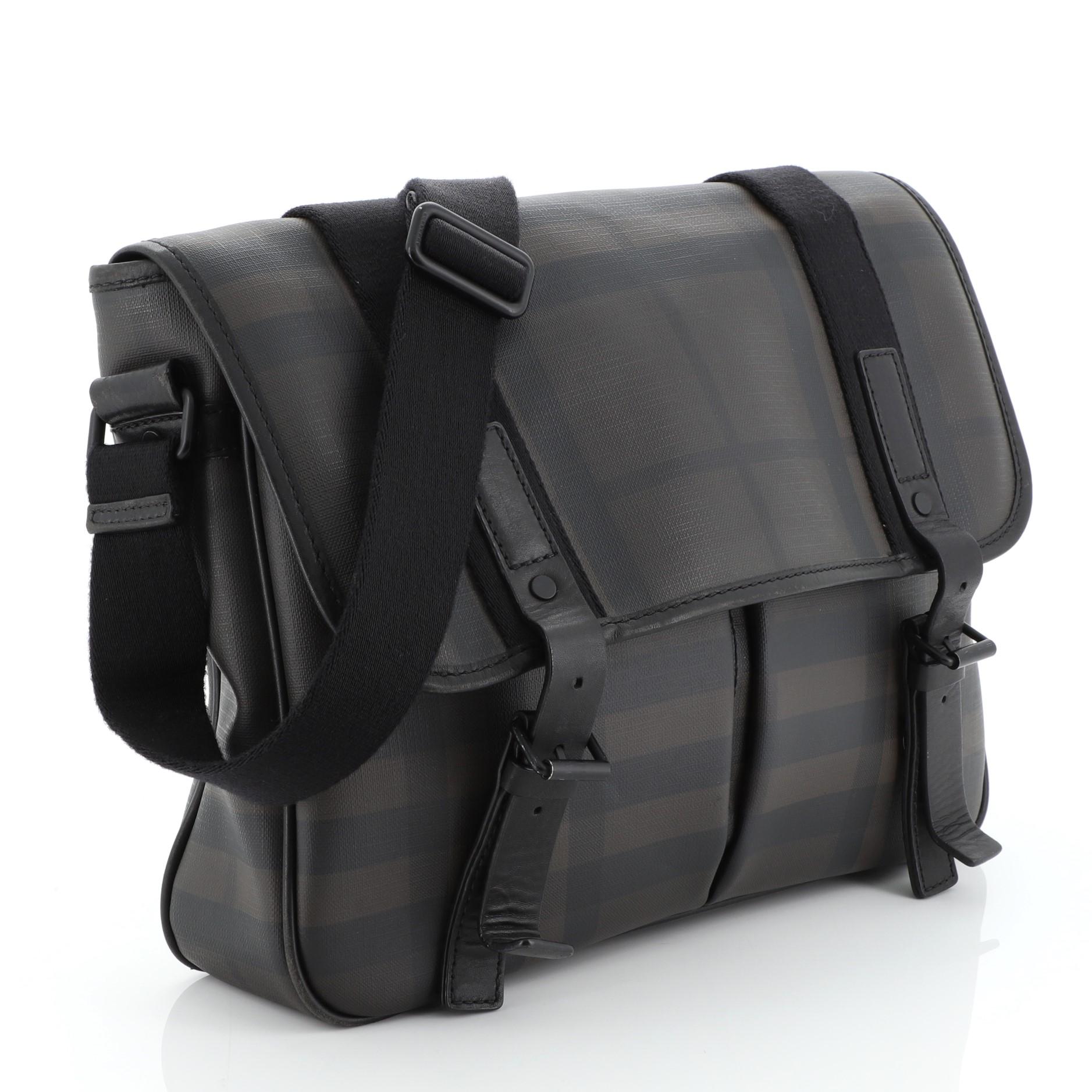 This Burberry Grifford Messenger Bag Smoked Check Coated Canvas Small, crafted in black and brown smoked check coated canvas, features an adjustable shoulder strap, front flap with buckle closure and black and gunmetal-tone hardware. It opens to a