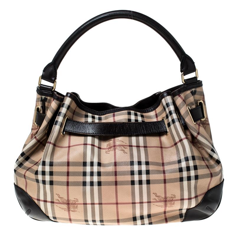 This beautifully stitched Haymarket Check canvas and leather hobo is by Burberry. With a capacious fabric-lined interior, it will house more than your essentials. Boasting of a seamless finish, this hobo offers style and utmost
