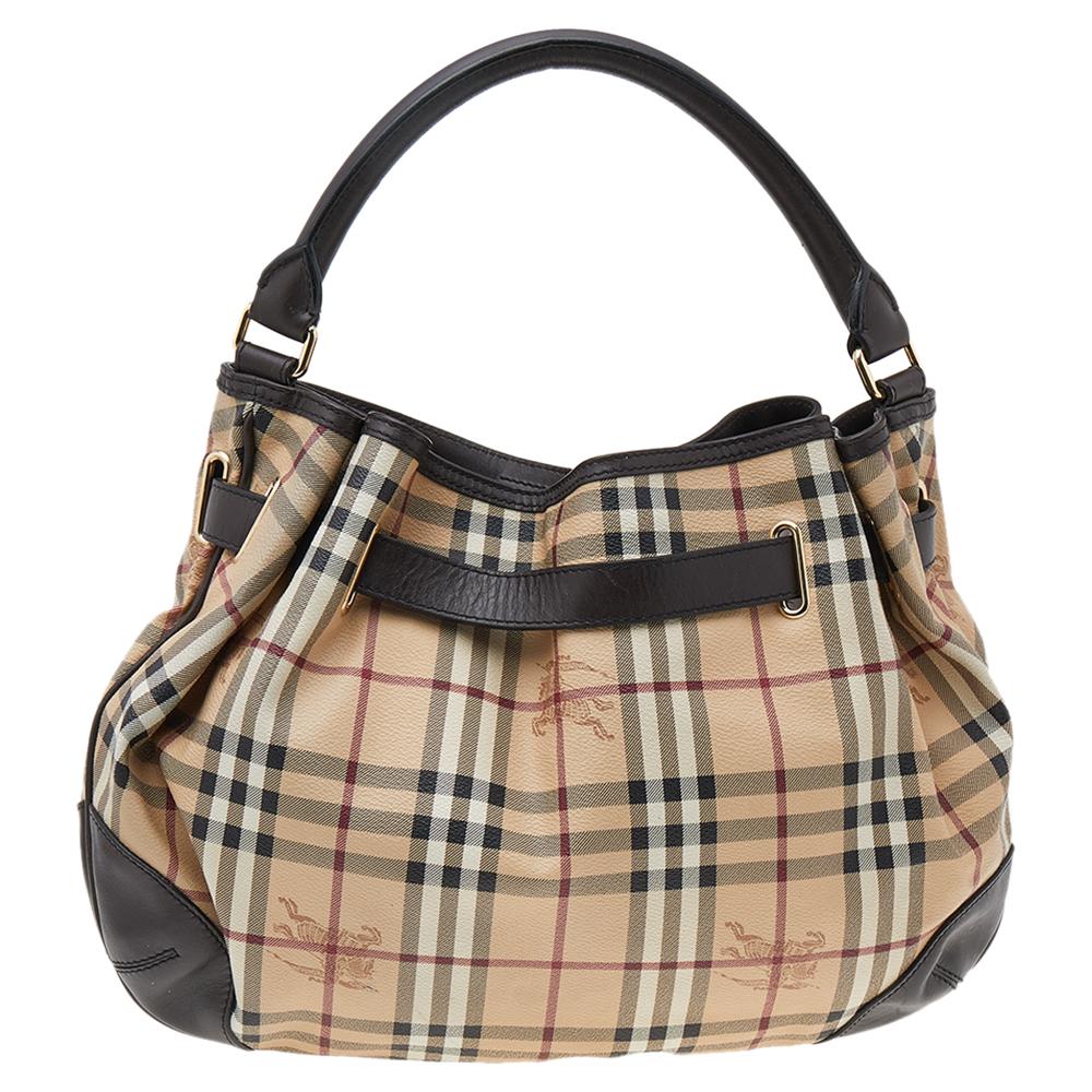This beautifully stitched Haymarket Check canvas and leather hobo is by Burberry. With a capacious fabric-lined interior, it will house more than your essentials. Boasting a seamless finish, this hobo offers style and utmost practicality.