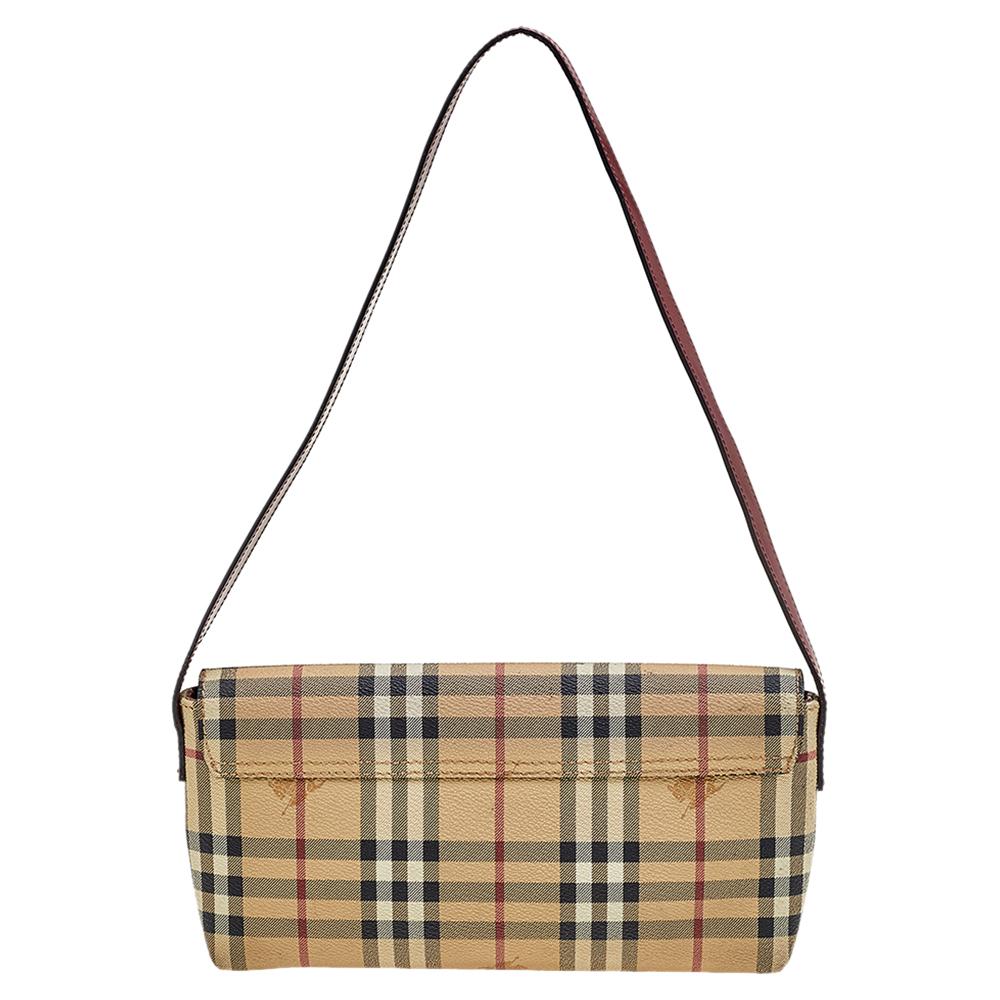 This small shoulder bag from the House of Burberry will bring elegance and luxe to your style. It is crafted using beige-brown Haymarket Check coated canvas and leather on the exterior and flaunts silver-toned hardware and a handle drop. It is