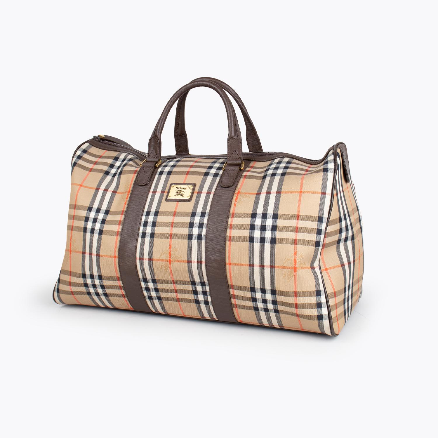 Tan and multicolor Haymarket check coated canvas Burberry duffle bag with

- Gold-tone hardware
- Brown leather trim
- Protective feet at base
- Dual rolled top handles, brown canvas lining, single pocket with zip closure at interior wall and zip