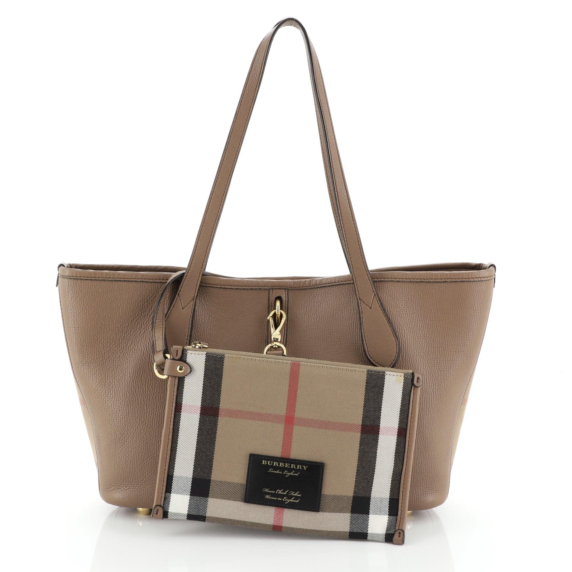 This Burberry Honeybrook Tote Leather Medium, crafted from brown and neutral printed leather, features dual flat leather handles, protective base studs, and gold-tone hardware. It opens to a check printed brown fabric interior. 

Estimated Retail