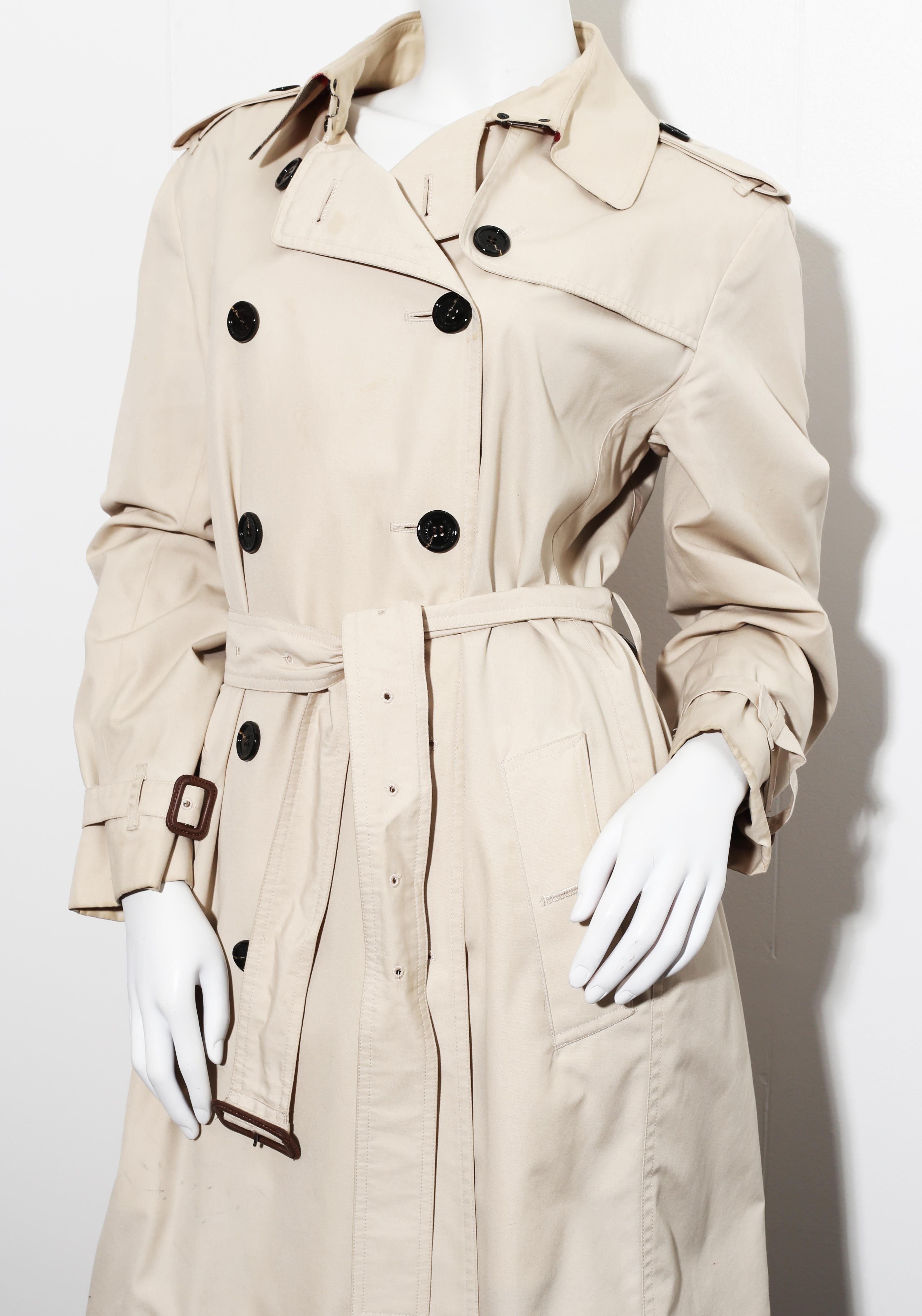 This light beige cotton blend Gabardine Trench Coat from Burberry is a brand icon. 
This version features a subtle sheen throughout, adding a touch of elegance to your look. Featuring epaulettes on the shoulders, an oversized collar, a storm flap, a