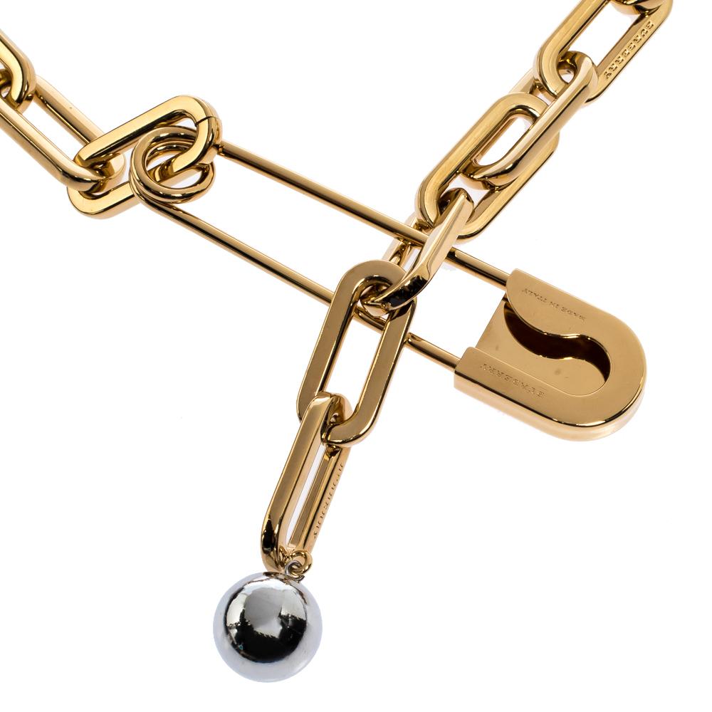 This Burberry necklace is a beauty. The design consist of a chainlink accented by a safety pin formally referred to as an 'archival kilt pin' and a contrasting bead. Sculpted from gold-tone metal, the short necklace can be worn on multiple