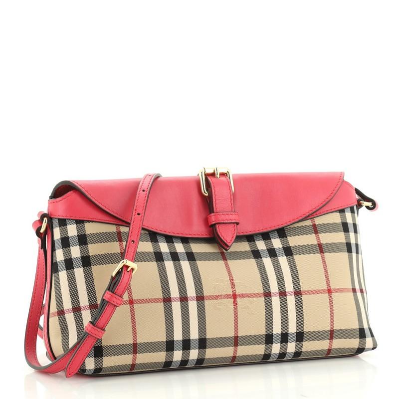 This Burberry Leah Clutch Bag Horseferry Check Canvas Small, crafted from neutral horseferry check canvas with pink leather, features an adjustable shoulder strap, fold-over top with decorative buckle flap and gold-tone hardware. Its magnetic snap