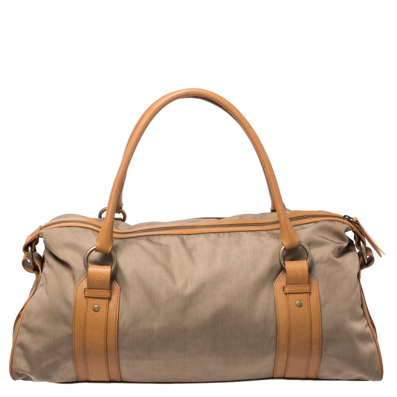 With an expertly lined fabric interior, this bag by Burberry can fit in all your essentials. The duffle bag is designed beautifully using canvas and leather. It has gold-tone hardware and two top handles.

