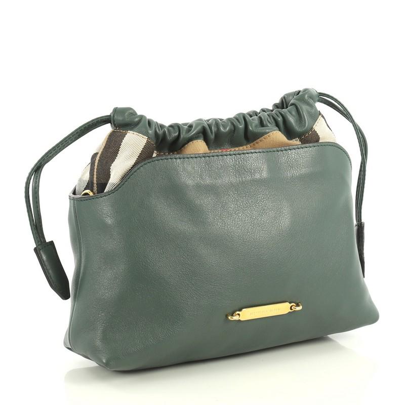 This Burberry Little Crush Crossbody Bag Leather and House Check Canvas, crafted in green leather and Burberry's signature Haymarket check canvas, features adjustable leather strap, bold Burberry logo, and gold-tone hardware. Its drawstring closure