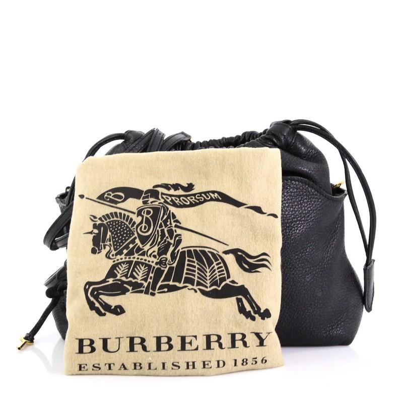 This Burberry Little Crush Lock Crossbody Leather, crafted in black leather, features adjustable leather strap, bold Burberry logo padlock and gold-tone hardware. Its drawstring closure opens to a black fabric interior with zip and slip pockets.