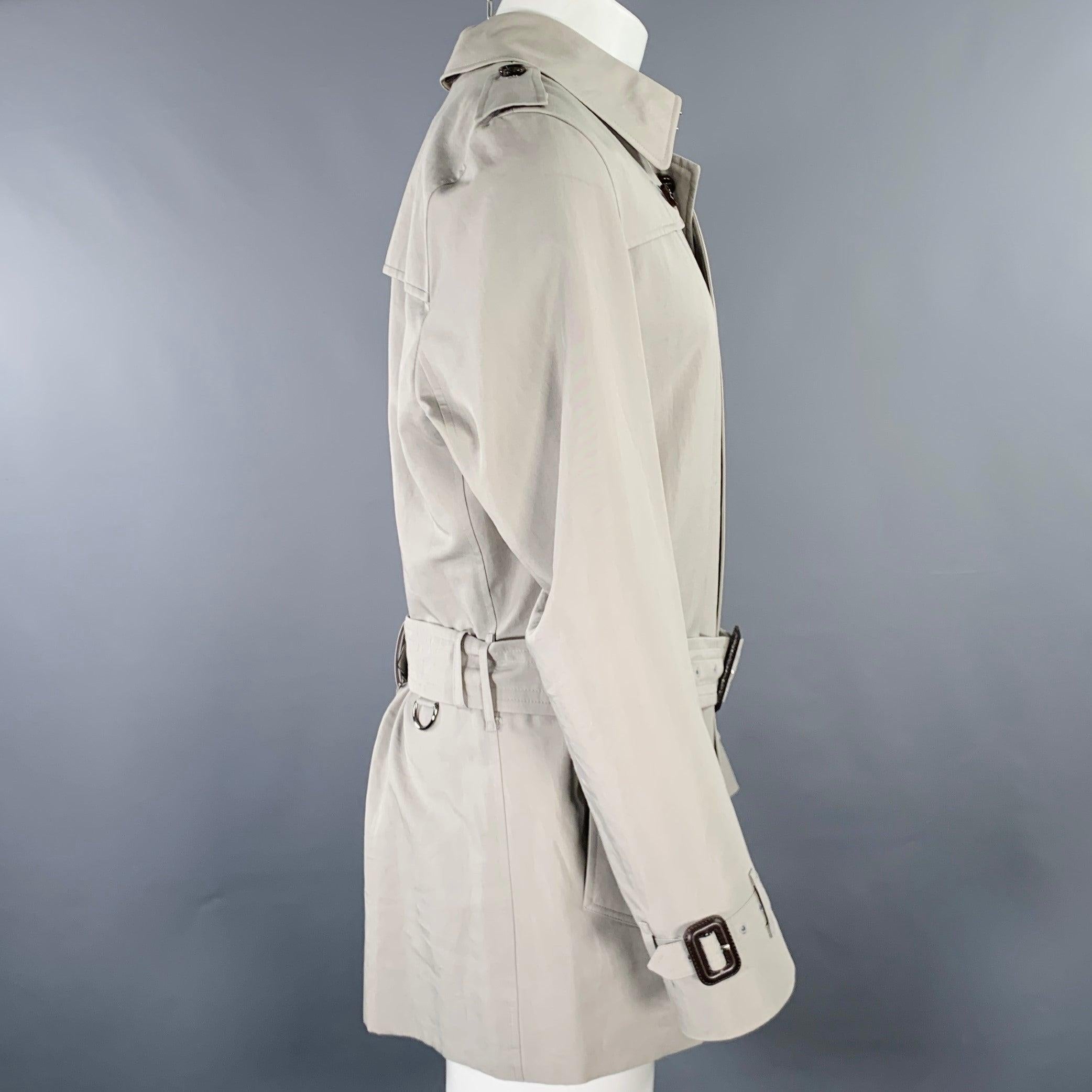 BURBERRY LONDON trenchcoat
in a grey cotton blend fabric featuring a belted style, signature Burberry plaid lining, and hidden button closure. Made in USA.Excellent Pre-Owned Condition. 

Marked:   40R 

Measurements: 
 
Shoulder: 17.5 inches Chest: