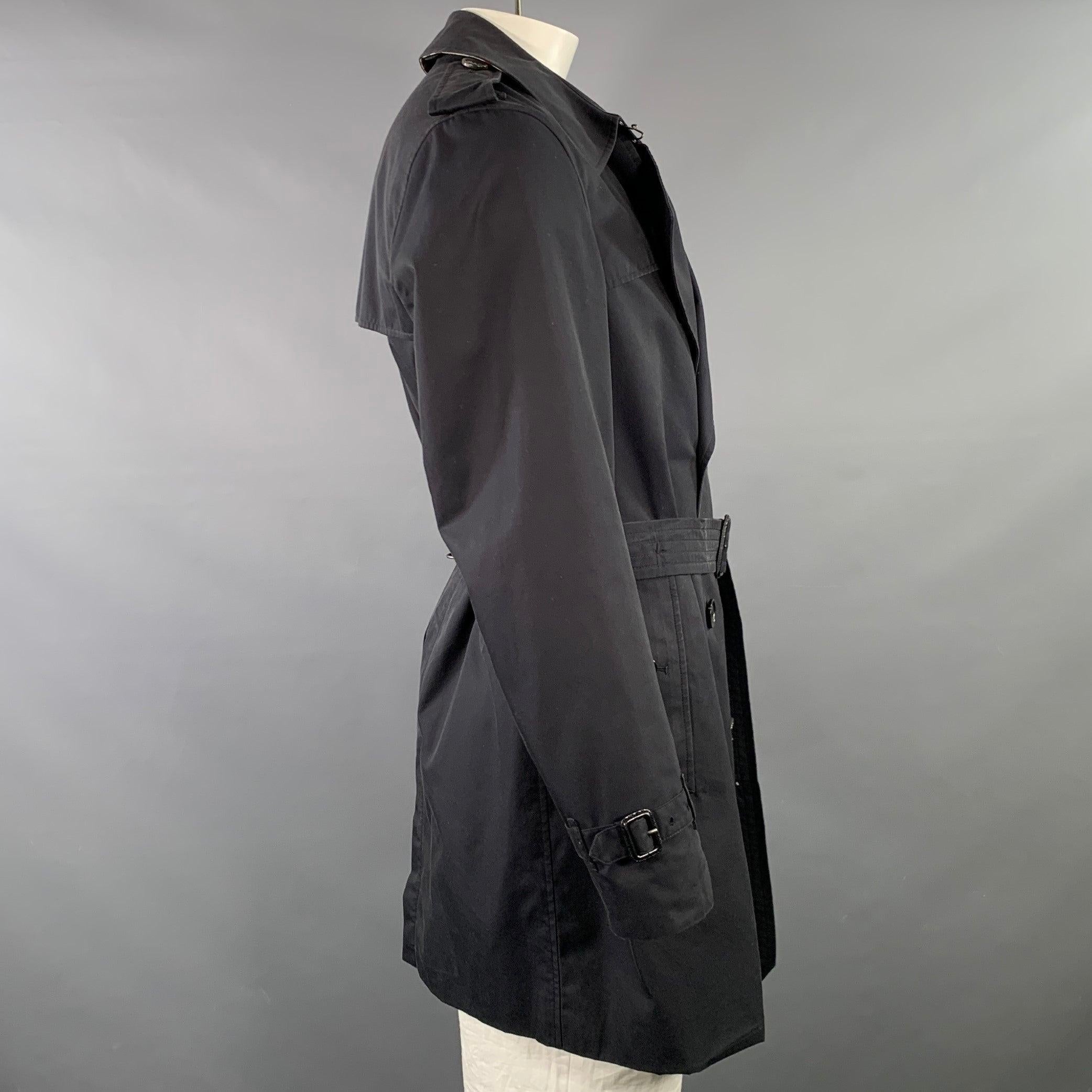 BURBERRY LONDON trenchcoat
in a black cotton featuring a double breasted style, two exterior buttoned pockets, and button closure with belt. Made in Italy.Very Good Pre-Owned Condition. Multiple minor marks. 

Marked:   IT 54 

Measurements: 
