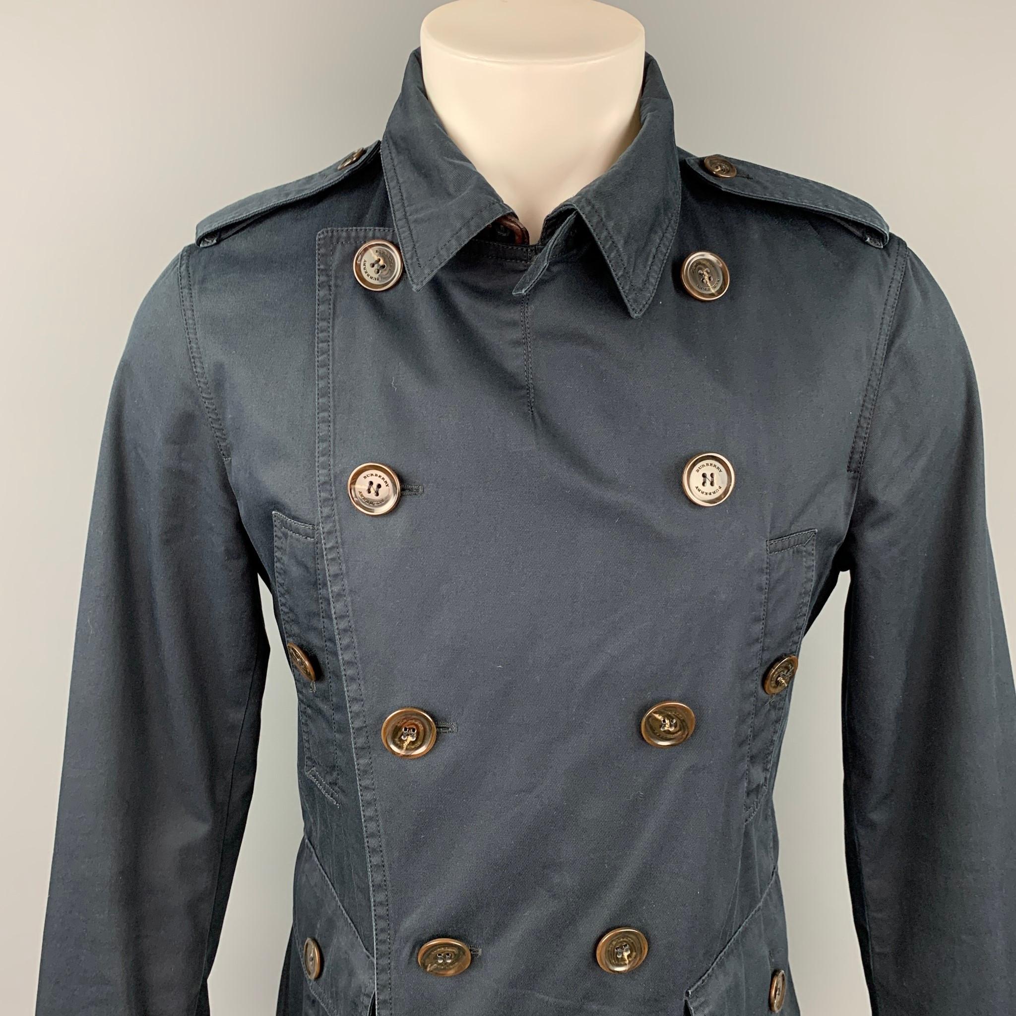 BURBERRY LONDON coat comes in a navy cotton / polyurethane with a full liner featuring patch pockets, epaulettes, sleeve straps, and a double breasted closure. Made in Romania.

Very Good Pre-Owned Condition.
Marked: M

Measurements:

Shoulder: 17.5